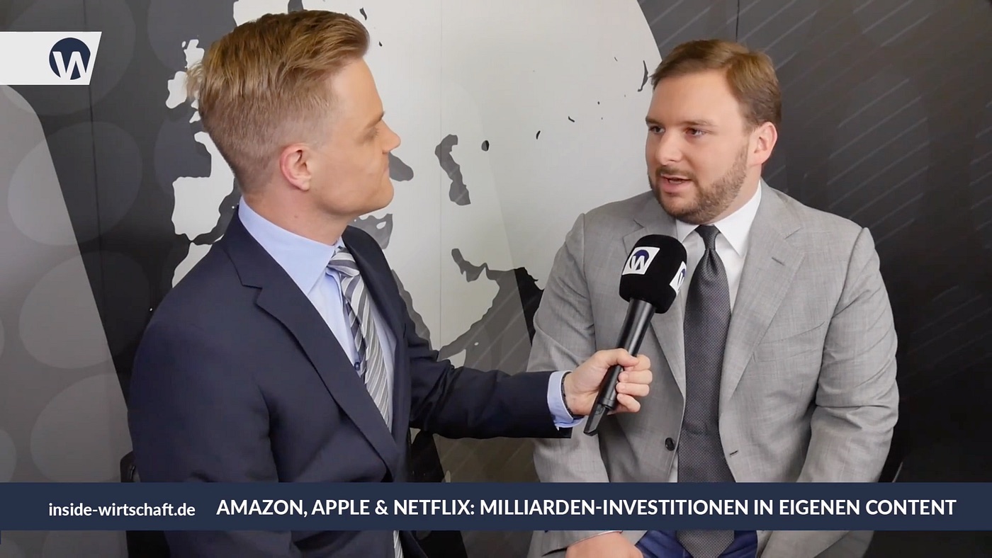 Manuel Koch holding a microphone as Tobias Jaeger answers