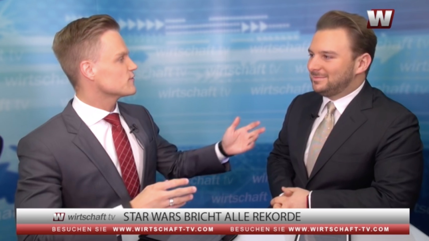 Manuel Koch gesturing as he interviews Tobias Jaeger in the studio